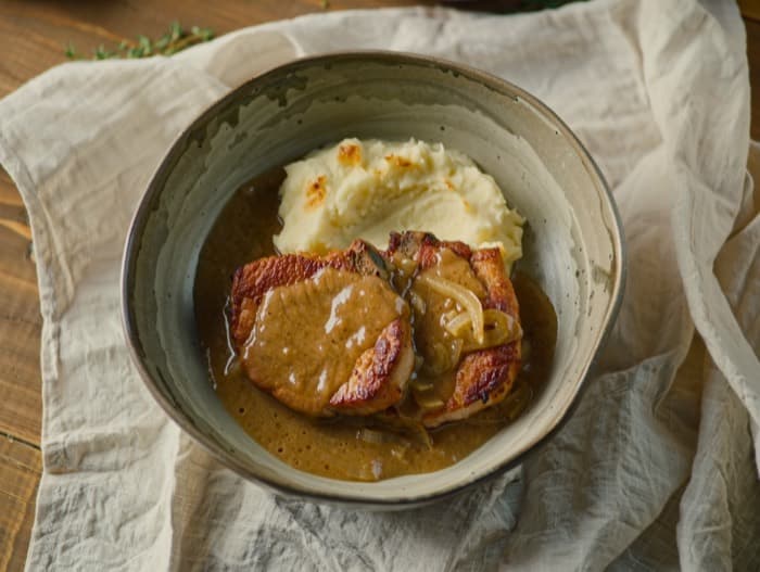 Smothered Pork Chops with Onion Gravy, plated and ready to serve